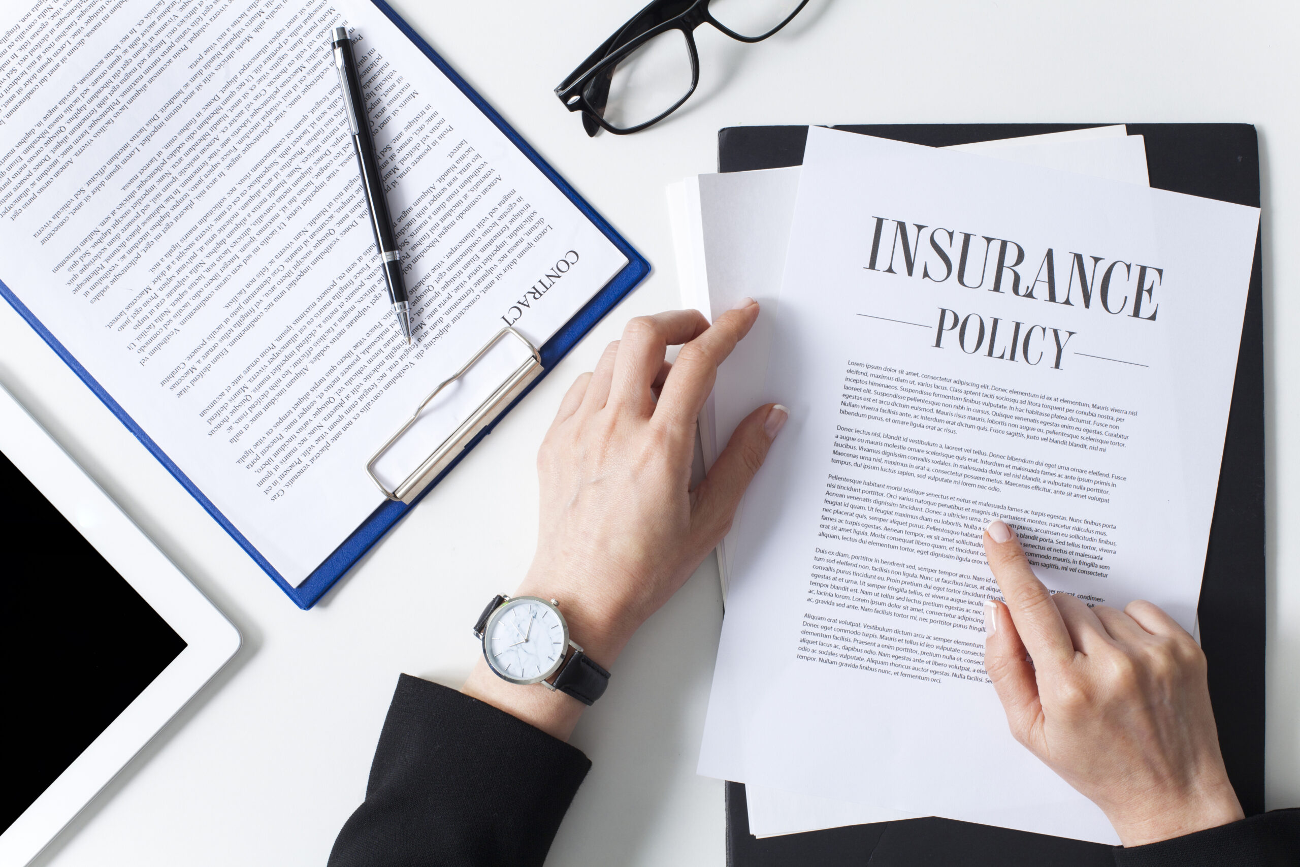 hands with watch reviewing insurance policy