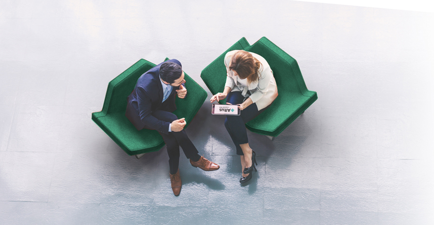Altus Partners colleagues collaborating in green chairs looking at a tablet